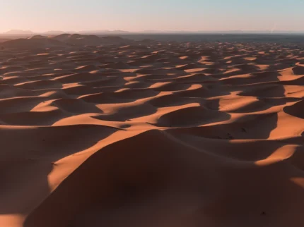 Towering sand dunes in the Sahara Desert near Merzouga, Morocco under a clear blue sky